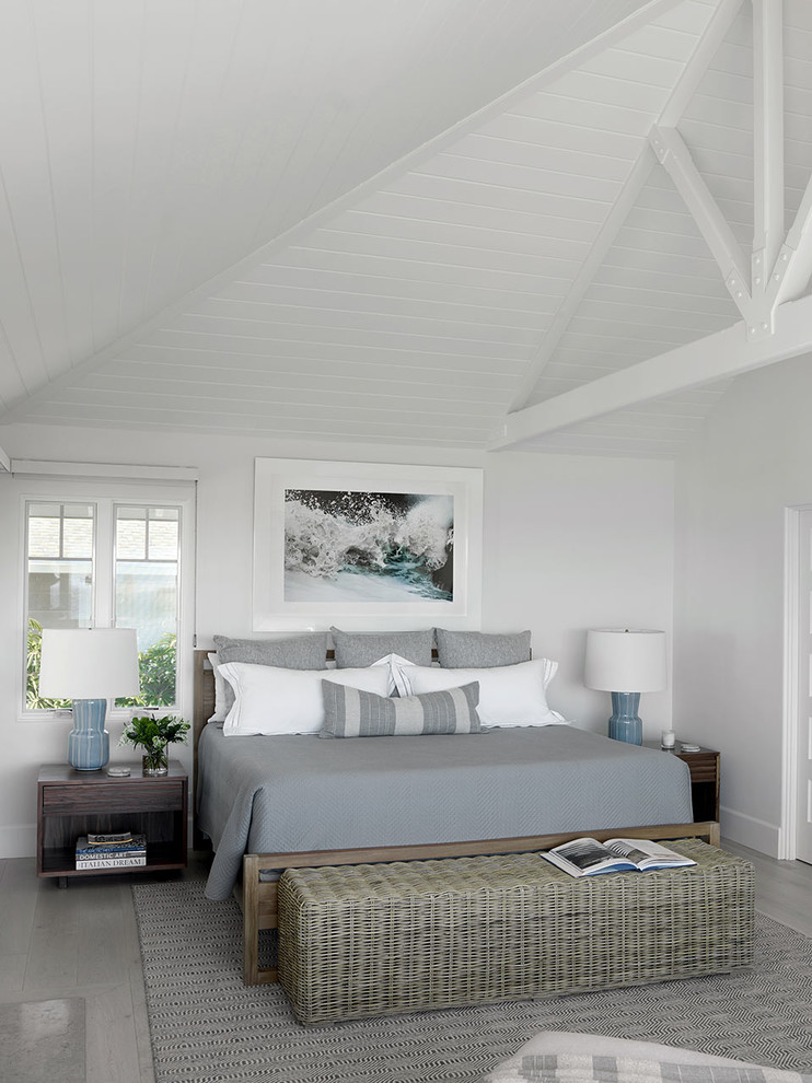 Photo of a beach style bedroom in Orange County with white walls, light hardwood floors and grey floor.