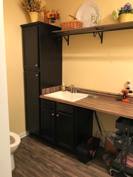 Photo of a laundry room in Indianapolis with a drop-in sink, flat-panel cabinets, dark wood cabinets and laminate benchtops.