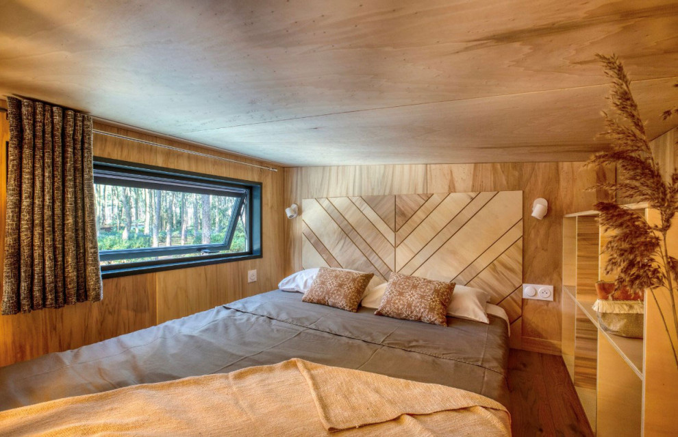 Immagine di una piccola camera da letto rustica con parquet chiaro, pavimento marrone, soffitto in perlinato e boiserie