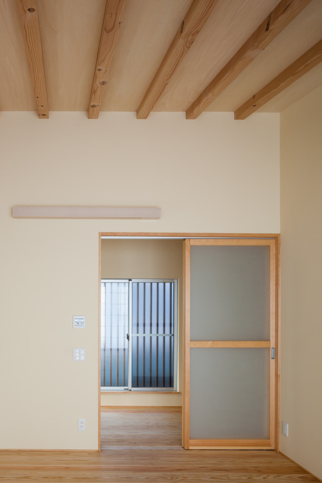 Ispirazione per un corridoio di medie dimensioni con pareti beige, parquet chiaro, una porta scorrevole, una porta marrone, soffitto in carta da parati e pareti in legno