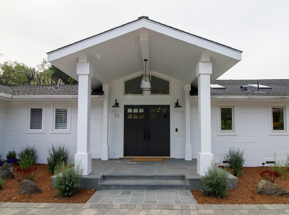 Mid-sized modern front yard verandah in San Francisco with with columns, stamped concrete and a roof extension.