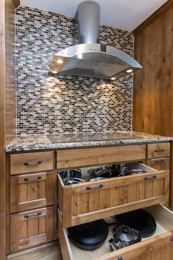 Eat-in kitchen - large rustic light wood floor eat-in kitchen idea with a farmhouse sink, light wood cabinets, granite countertops, beige backsplash, glass tile backsplash, stainless steel appliances and beige countertops