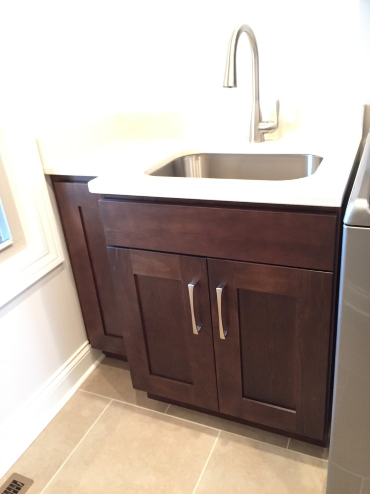 Design ideas for a mid-sized transitional single-wall dedicated laundry room in Other with an undermount sink, shaker cabinets, dark wood cabinets, beige walls, ceramic floors and a side-by-side washer and dryer.