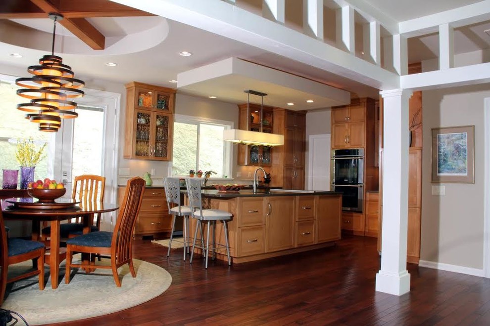 Eat-in kitchen - mid-sized transitional l-shaped medium tone wood floor and brown floor eat-in kitchen idea with recessed-panel cabinets, medium tone wood cabinets, stainless steel appliances, an island, an undermount sink and granite countertops