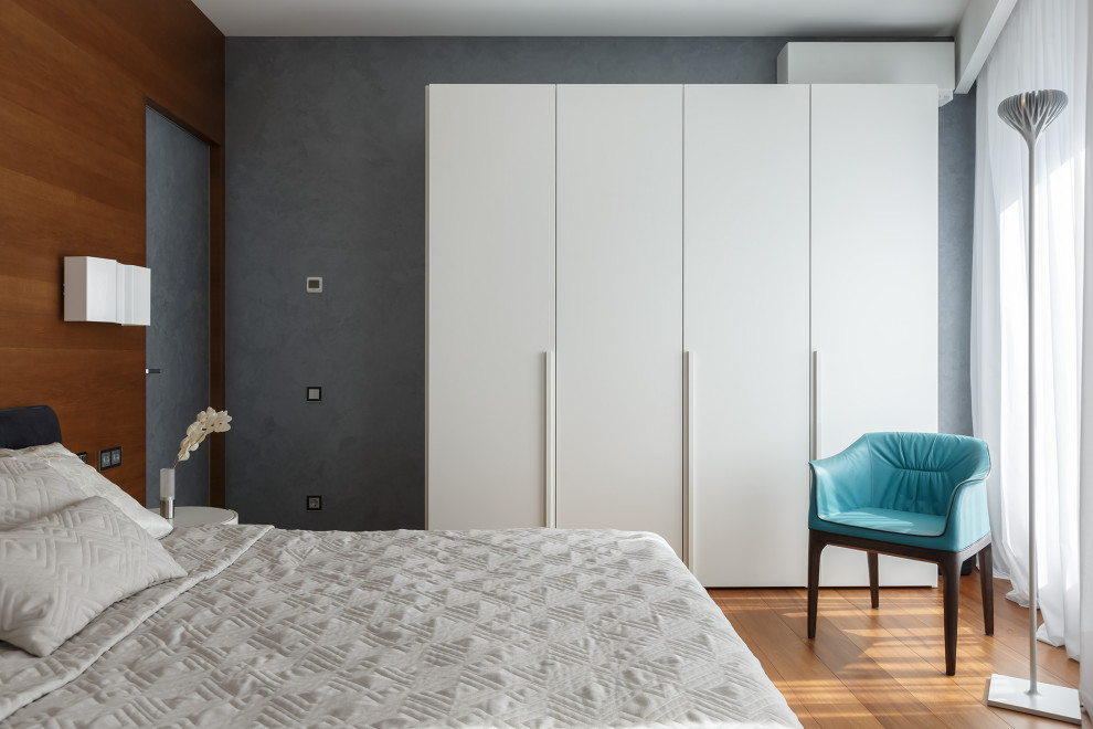 Пример оригинального дизайна: хозяйская, серо-белая спальня среднего размера в современном стиле с серыми стенами, паркетным полом среднего тона, коричневым полом, панелями на части стены и тюлем