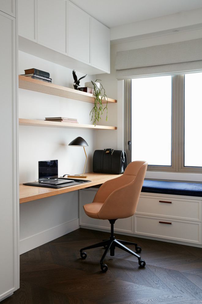 Immagine di uno studio chic con pareti bianche, parquet scuro, scrivania incassata e pavimento marrone