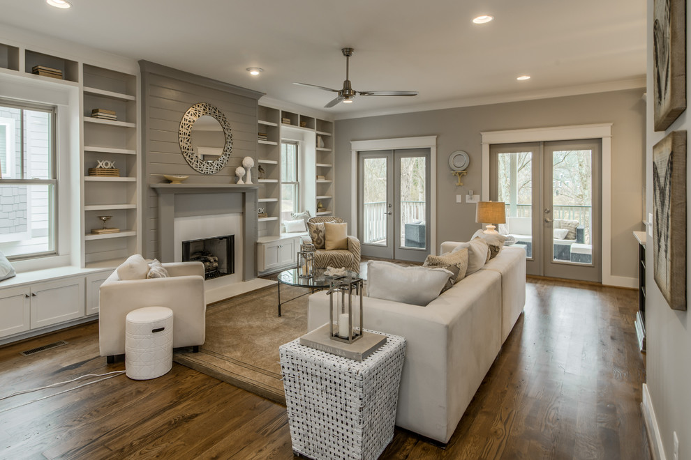 Example of a mid-sized transitional formal and open concept medium tone wood floor living room design in Nashville with gray walls, a standard fireplace, no tv and a shiplap fireplace