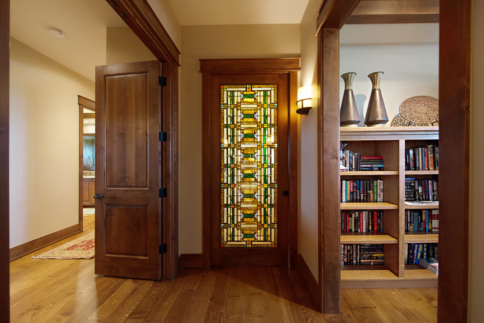 This is an example of an expansive arts and crafts hallway in Denver with white walls and medium hardwood floors.