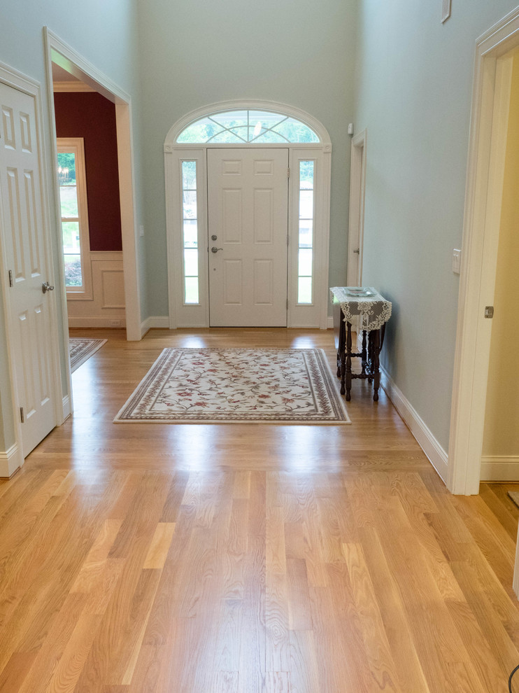 Inspiration for a mid-sized transitional light wood floor hallway remodel in New York with gray walls