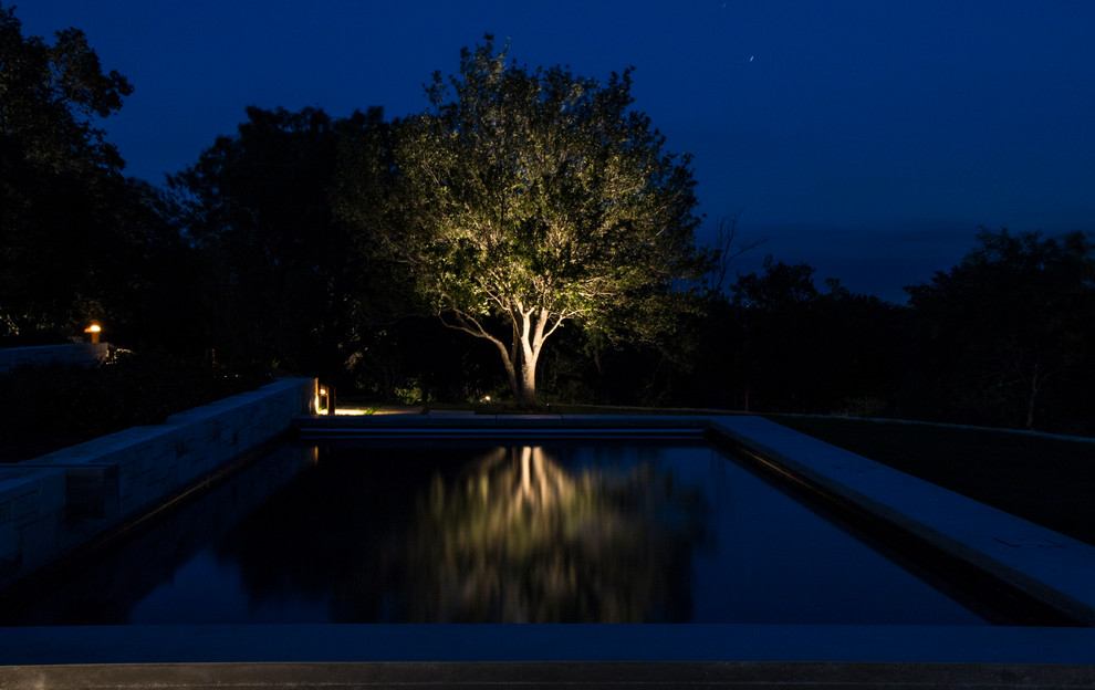 Example of a large mountain style backyard rectangular lap pool fountain design in Austin