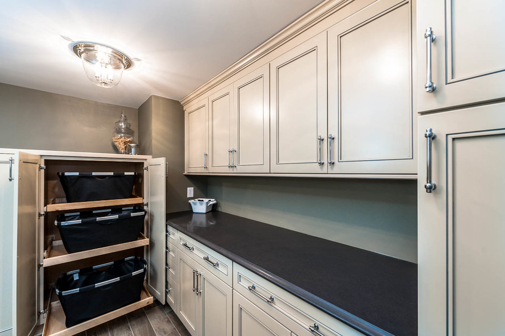 Photo of an expansive traditional galley utility room in Indianapolis with an undermount sink, beige cabinets, quartz benchtops, grey walls, porcelain floors, a side-by-side washer and dryer and recessed-panel cabinets.