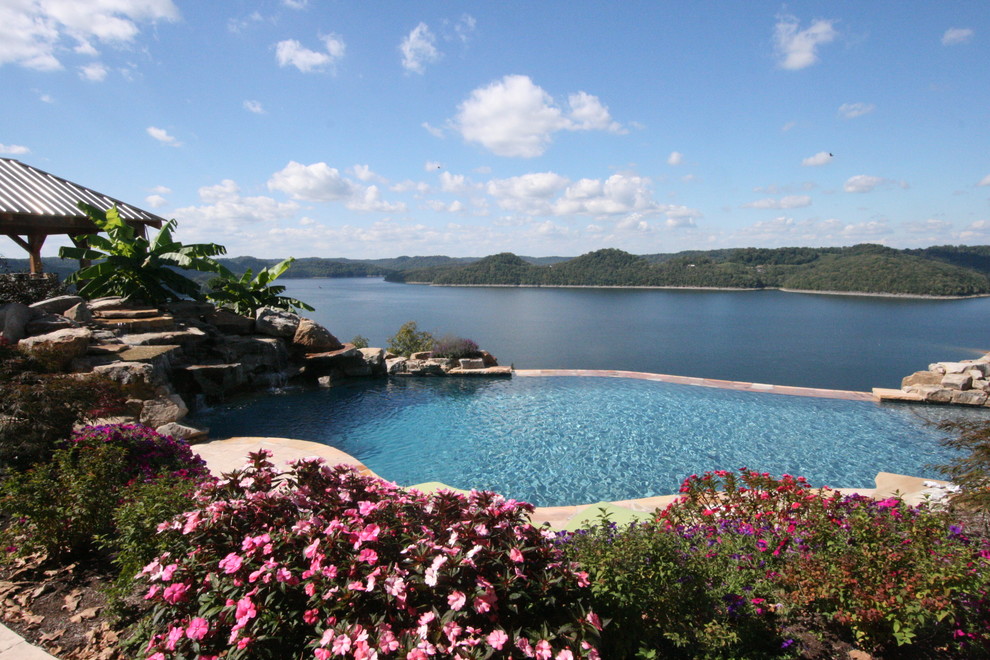 Inspiration for a large beach style backyard custom-shaped infinity pool in Nashville with a hot tub and natural stone pavers.