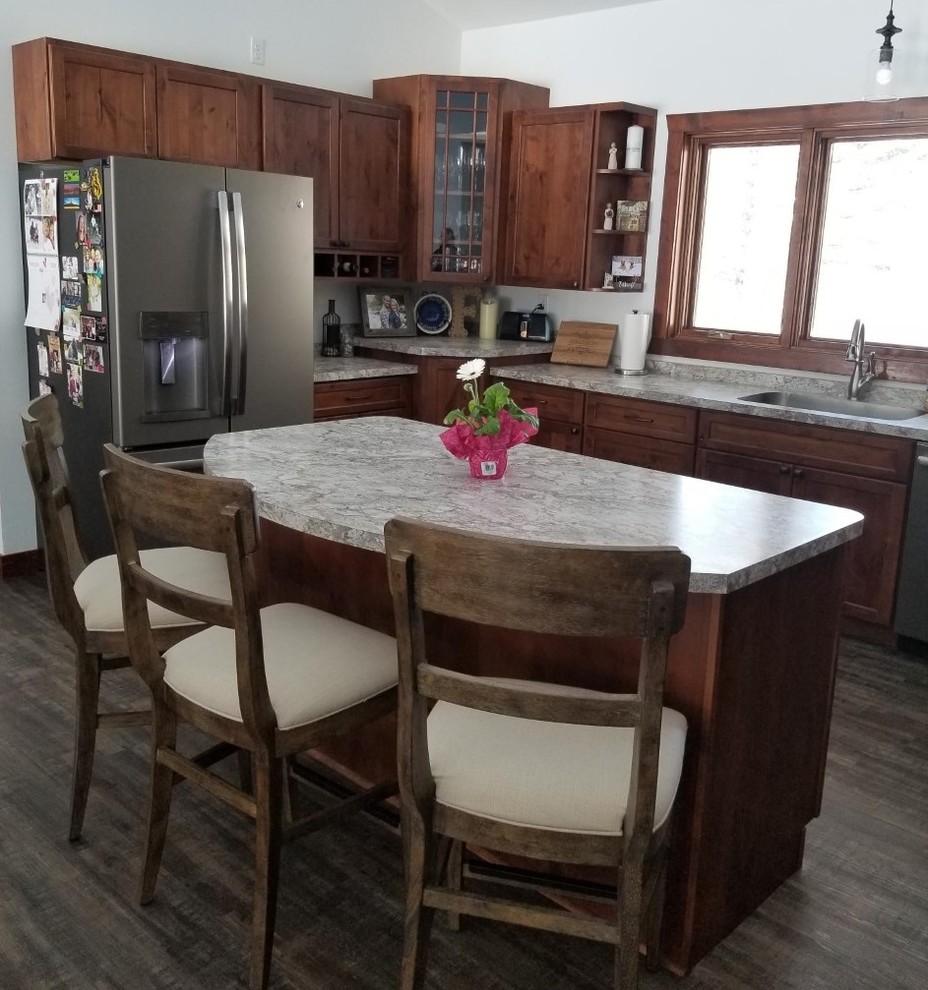 Transitional u-shaped kitchen photo with an undermount sink, shaker cabinets, laminate countertops, stainless steel appliances and an island