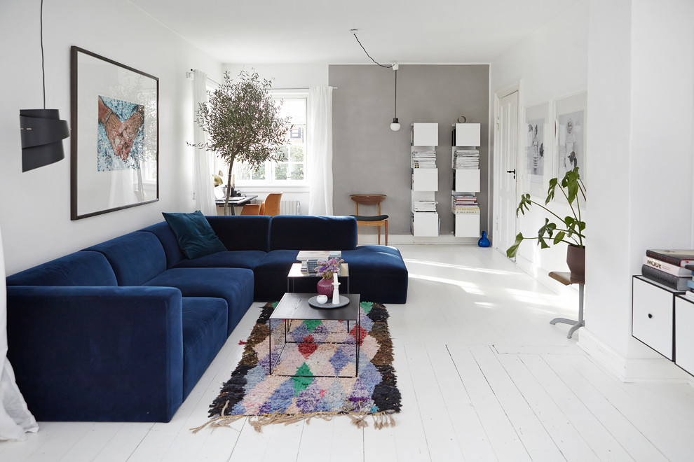 Large scandinavian open concept living room in Wiltshire with white walls and painted wood floors.