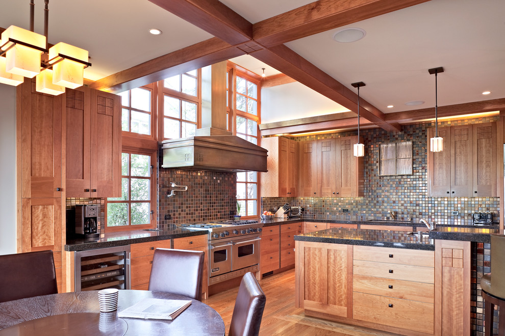 This is an example of a large arts and crafts l-shaped eat-in kitchen in San Francisco with mosaic tile splashback, stainless steel appliances, an undermount sink, multi-coloured splashback, medium hardwood floors, brown floor, black benchtop, shaker cabinets, medium wood cabinets, granite benchtops and with island.