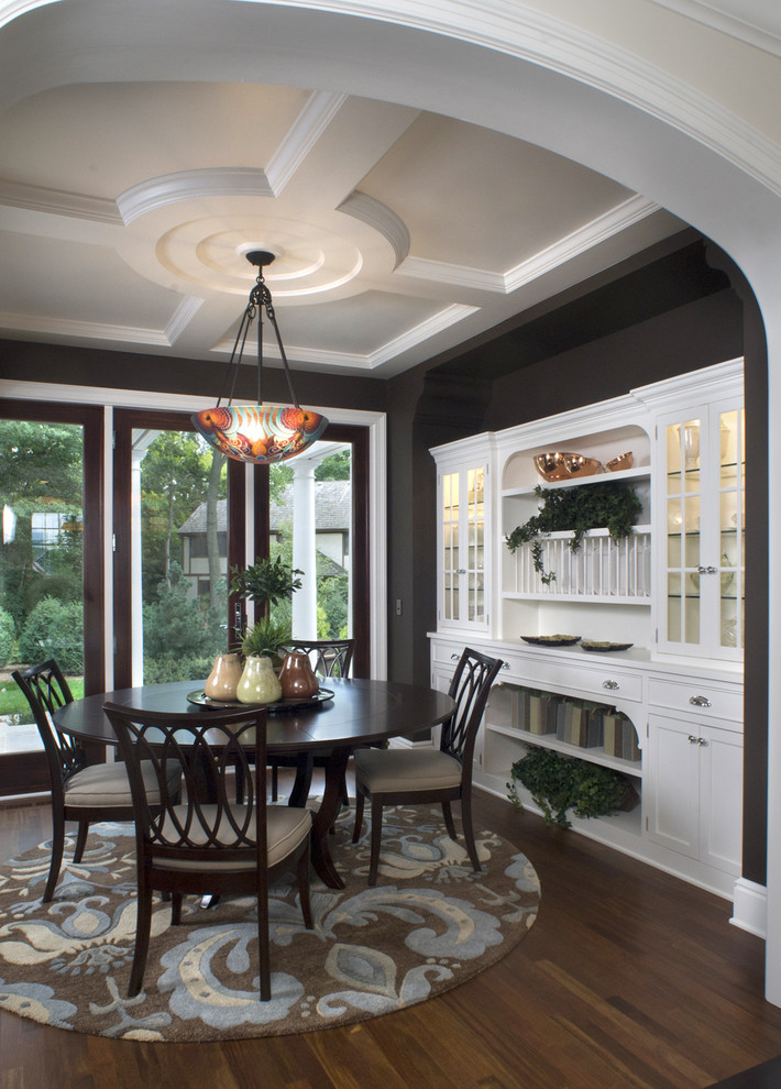 This is an example of a traditional dining room in Minneapolis with black walls and brown floor.
