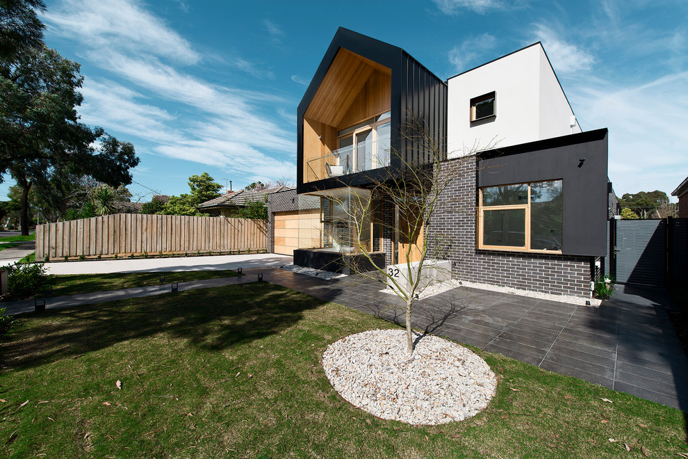 Design ideas for a modern two-storey black exterior in Melbourne with metal siding.