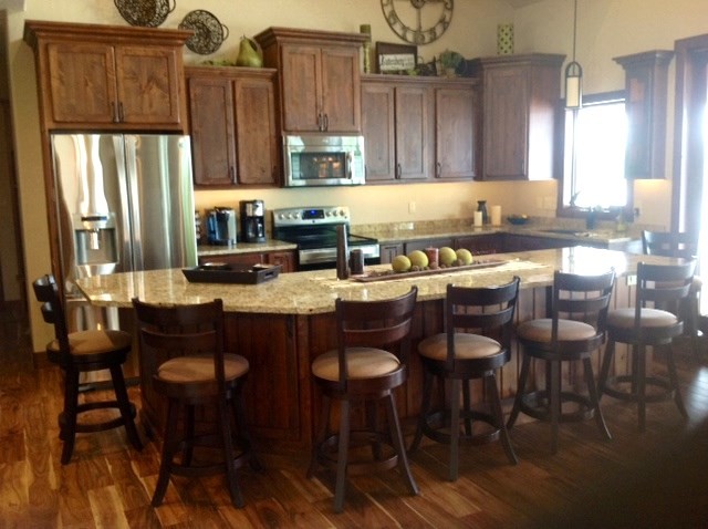 Inspiration for a large rustic l-shaped eat-in kitchen remodel in Cedar Rapids with flat-panel cabinets, medium tone wood cabinets and an island