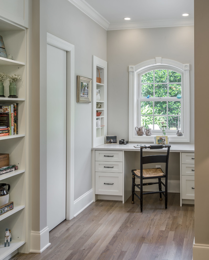 Design ideas for a small transitional home office in Nashville with light hardwood floors and a built-in desk.