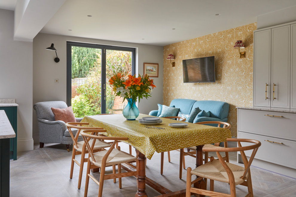 Eclectic kitchen/dining room in Gloucestershire with yellow walls, no fireplace, grey floors and wallpapered walls.
