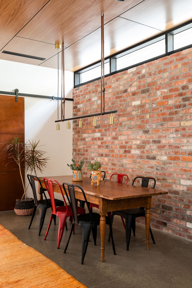 This is an example of a mid-sized industrial open plan dining in Perth with white walls, concrete floors, no fireplace and grey floor.