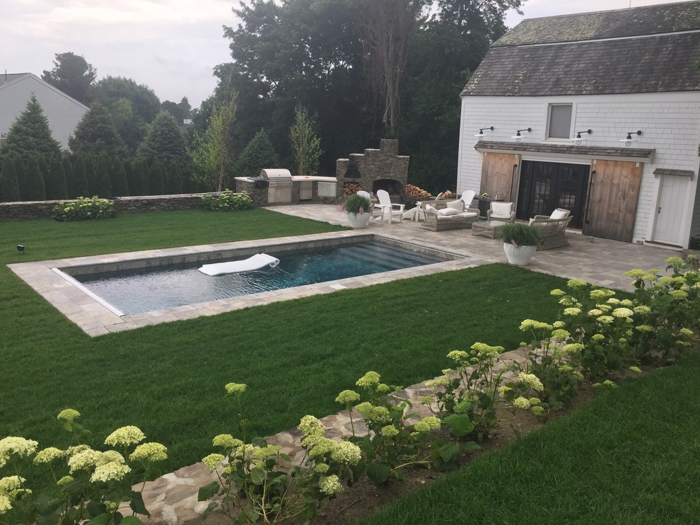 Mid-sized traditional backyard rectangular lap pool in Boston with natural stone pavers.