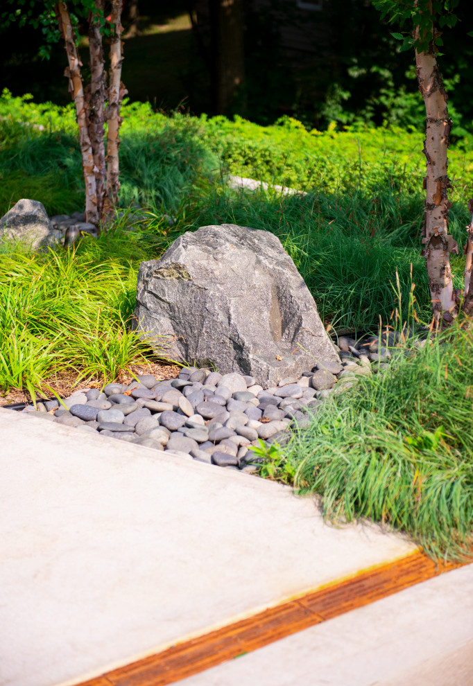 Esempio di un grande vialetto d'ingresso design esposto in pieno sole davanti casa in estate con sassi e rocce