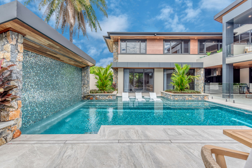 This is an example of an expansive contemporary rectangular swimming pool in Cairns with tiled flooring.