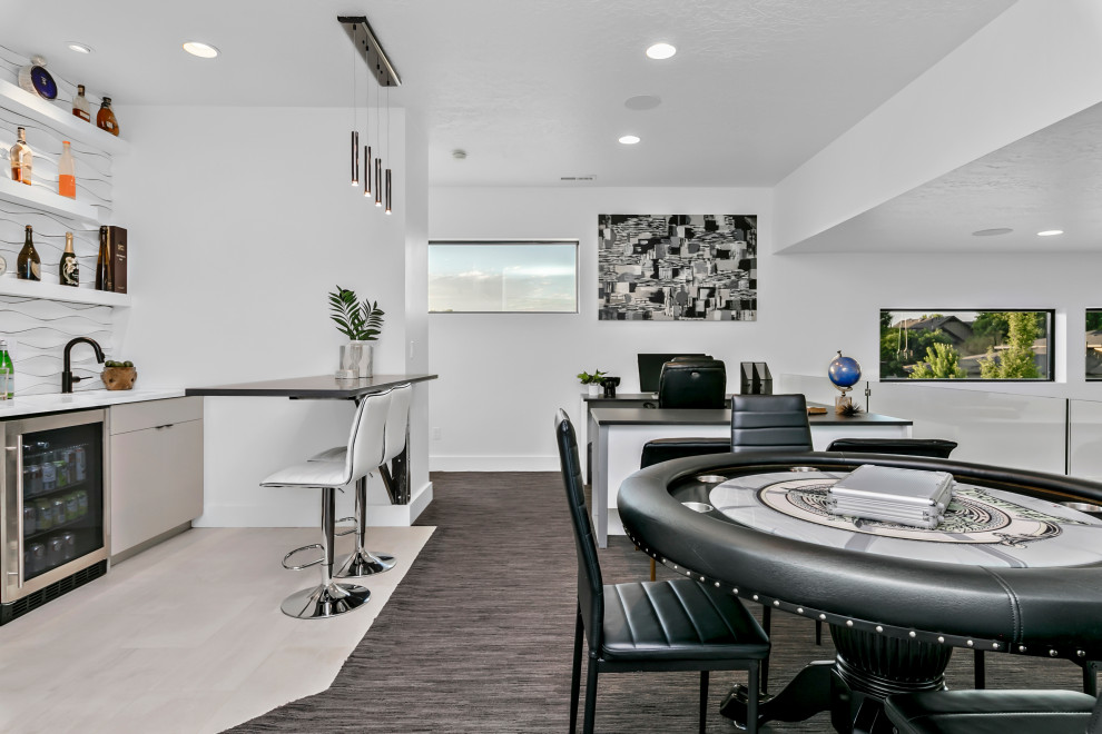 This is an example of an expansive modern loft-style family room in Boise with a game room, white walls, carpet, a wall-mounted tv, multi-coloured floor, vaulted and panelled walls.