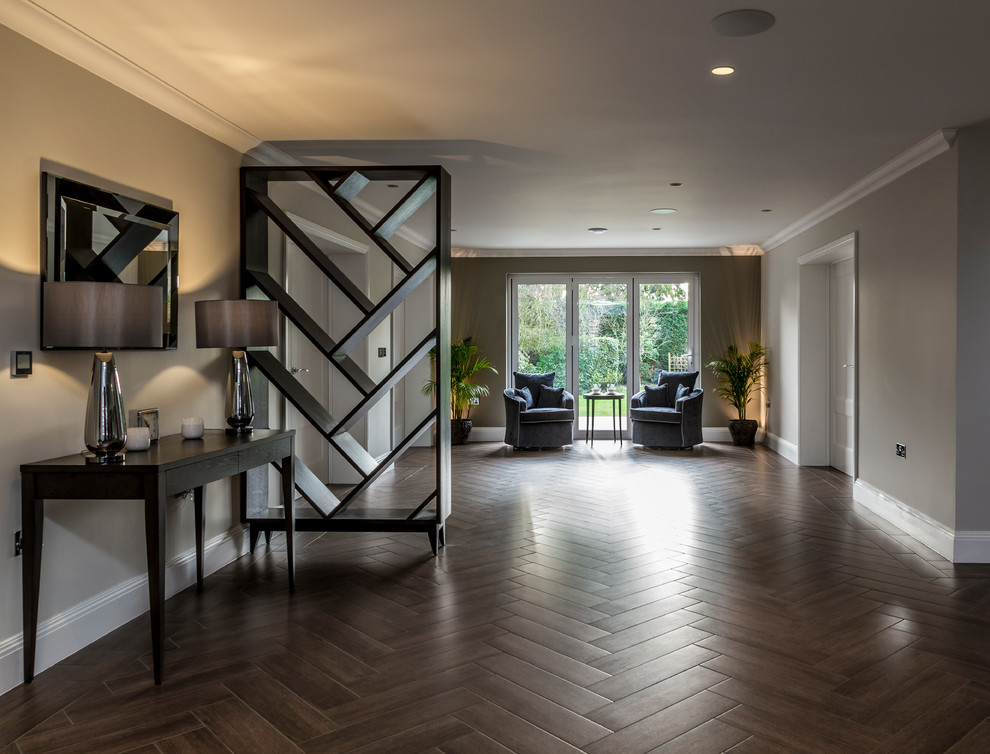 Design ideas for an expansive contemporary entry hall in Hertfordshire with grey walls, ceramic floors, a single front door, brown floor and a dark wood front door.