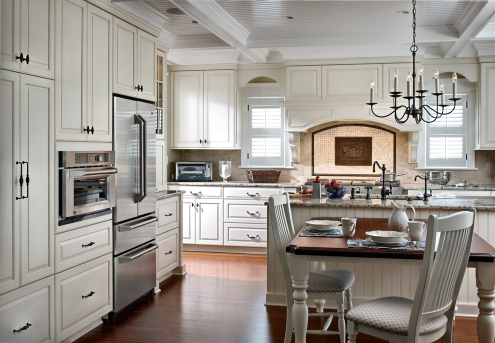 Traditional l-shaped eat-in kitchen in Philadelphia with an integrated sink, raised-panel cabinets and white cabinets.