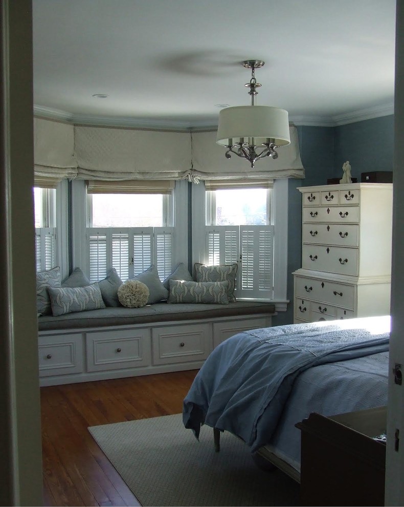 Transitional master bedroom in New York with blue walls and medium hardwood floors.