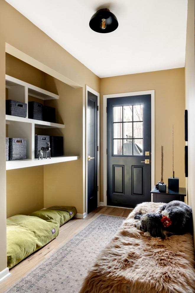 Inspiration for a mid-sized transitional medium tone wood floor and brown floor mudroom remodel in Minneapolis with brown walls and a black front door