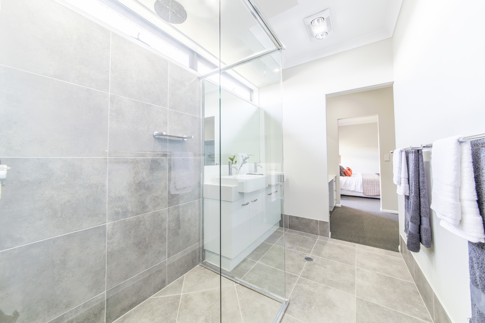 Design ideas for a small contemporary master bathroom in Other with furniture-like cabinets, white cabinets, a corner shower, a two-piece toilet, gray tile, cement tile, beige walls, ceramic floors, a drop-in sink, quartzite benchtops, grey floor and a hinged shower door.