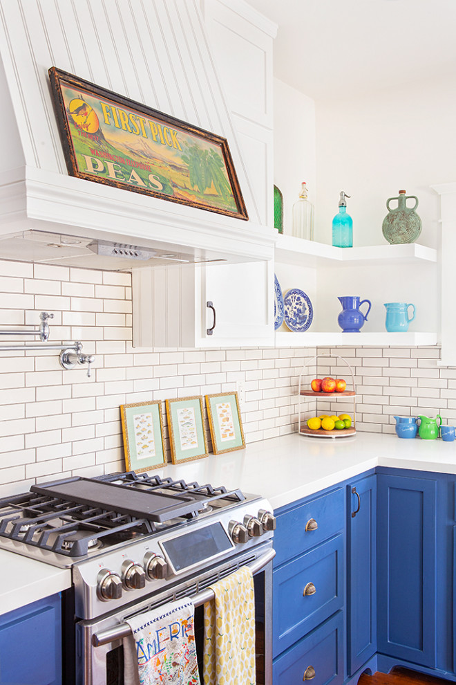 Enclosed kitchen - mid-sized craftsman l-shaped enclosed kitchen idea in Los Angeles with a farmhouse sink, shaker cabinets, blue cabinets, quartz countertops, white backsplash, ceramic backsplash, stainless steel appliances, an island and white countertops