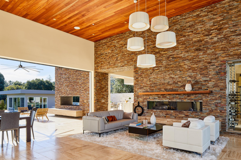 Trendy open concept travertine floor, beige floor and wood ceiling living room photo with beige walls, a stone fireplace and a ribbon fireplace