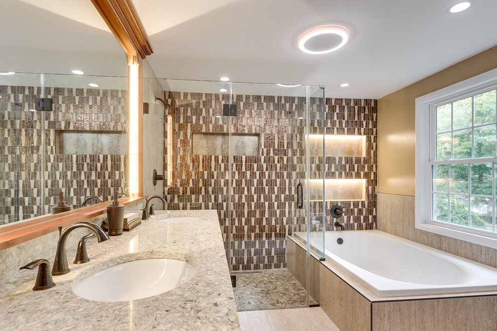 This is an example of a large traditional master bathroom in DC Metro with raised-panel cabinets, medium wood cabinets, a corner tub, a corner shower, a two-piece toilet, beige tile, brown tile, ceramic tile, beige walls, bamboo floors, an undermount sink and granite benchtops.