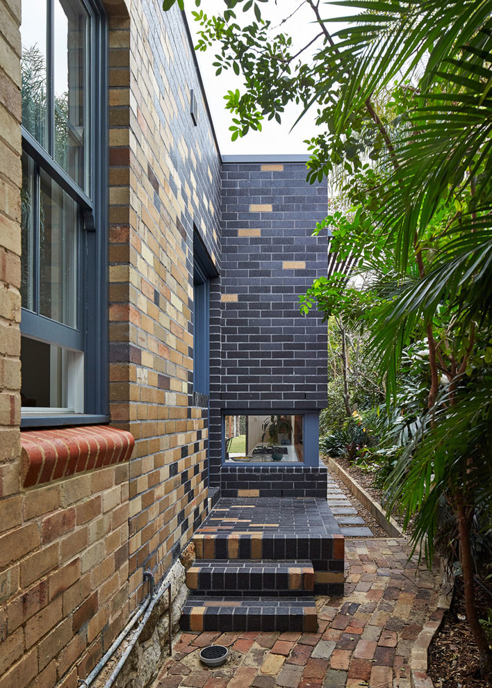 Photo of a mid-sized contemporary one-storey brick black exterior in Sydney.