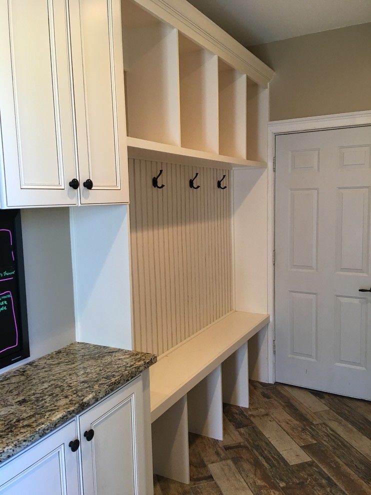Photo of a large traditional galley utility room in Atlanta with an undermount sink, recessed-panel cabinets, white cabinets, granite benchtops, brown walls and a side-by-side washer and dryer.