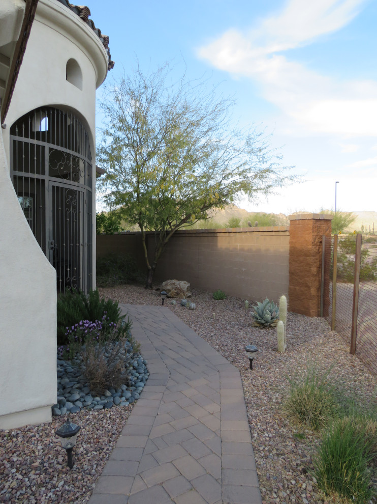 Idee per un giardino xeriscape stile americano esposto in pieno sole di medie dimensioni e davanti casa in estate con pavimentazioni in cemento, un ingresso o sentiero e recinzione in metallo
