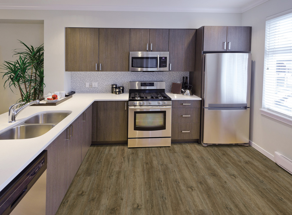 Transitional u-shaped light wood floor and beige floor enclosed kitchen photo in Orlando with an undermount sink, flat-panel cabinets, dark wood cabinets, granite countertops, white backsplash, subway tile backsplash, stainless steel appliances and an island