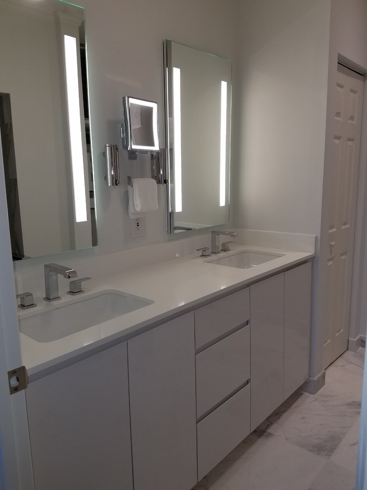 Inspiration for a small transitional master white tile and marble tile marble floor and white floor double shower remodel in Miami with flat-panel cabinets, white cabinets, a one-piece toilet, blue walls, an undermount sink, quartz countertops and a hinged shower door
