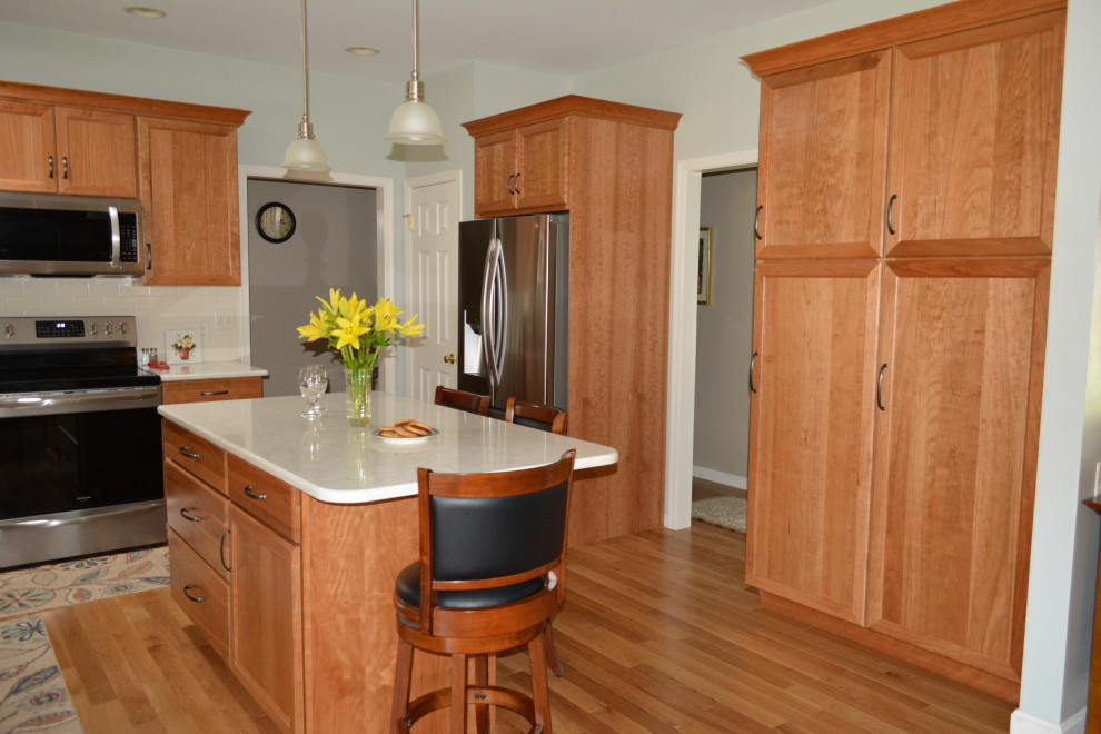 Mid-sized transitional u-shaped light wood floor and brown floor eat-in kitchen photo in Other with an undermount sink, flat-panel cabinets, light wood cabinets, quartz countertops, white backsplash, porcelain backsplash, stainless steel appliances, an island and white countertops
