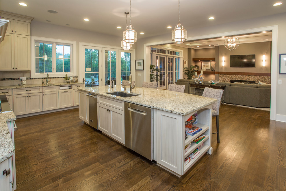 Example of a large transitional u-shaped medium tone wood floor kitchen design in Cincinnati with a single-bowl sink, shaker cabinets, gray cabinets, granite countertops, gray backsplash, porcelain backsplash, stainless steel appliances and an island