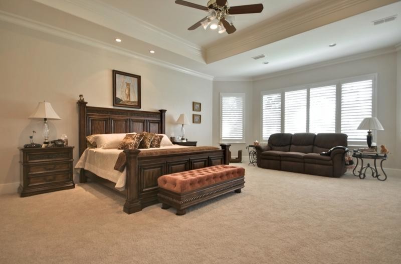 Example of a large classic master carpeted bedroom design in Dallas with beige walls, a standard fireplace and a stone fireplace