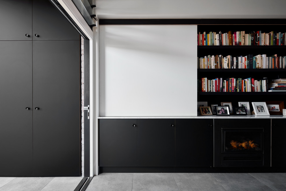 This is an example of a laundry room in Sydney with black cabinets and grey floor.