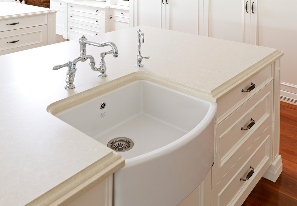This is an example of a transitional eat-in kitchen in Melbourne with a farmhouse sink, shaker cabinets, white cabinets, black appliances, medium hardwood floors and multiple islands.