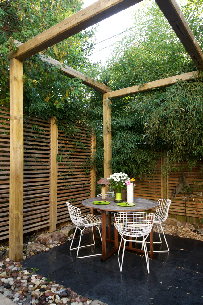 Design ideas for an asian patio in Toronto with a pergola.