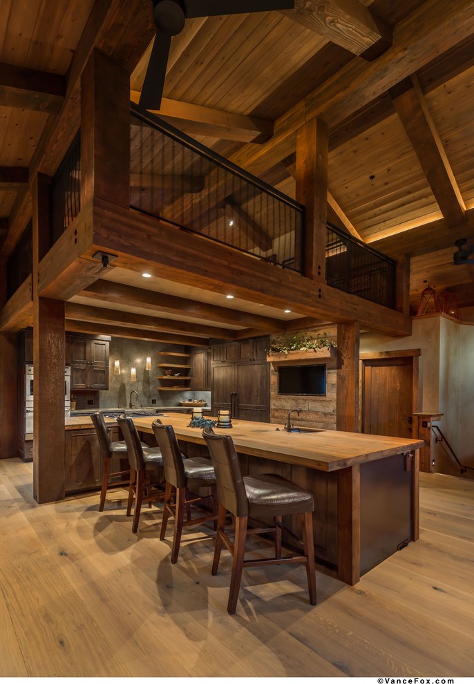 Mid-sized mountain style light wood floor kitchen photo with an undermount sink, shaker cabinets, dark wood cabinets, stainless steel appliances and an island