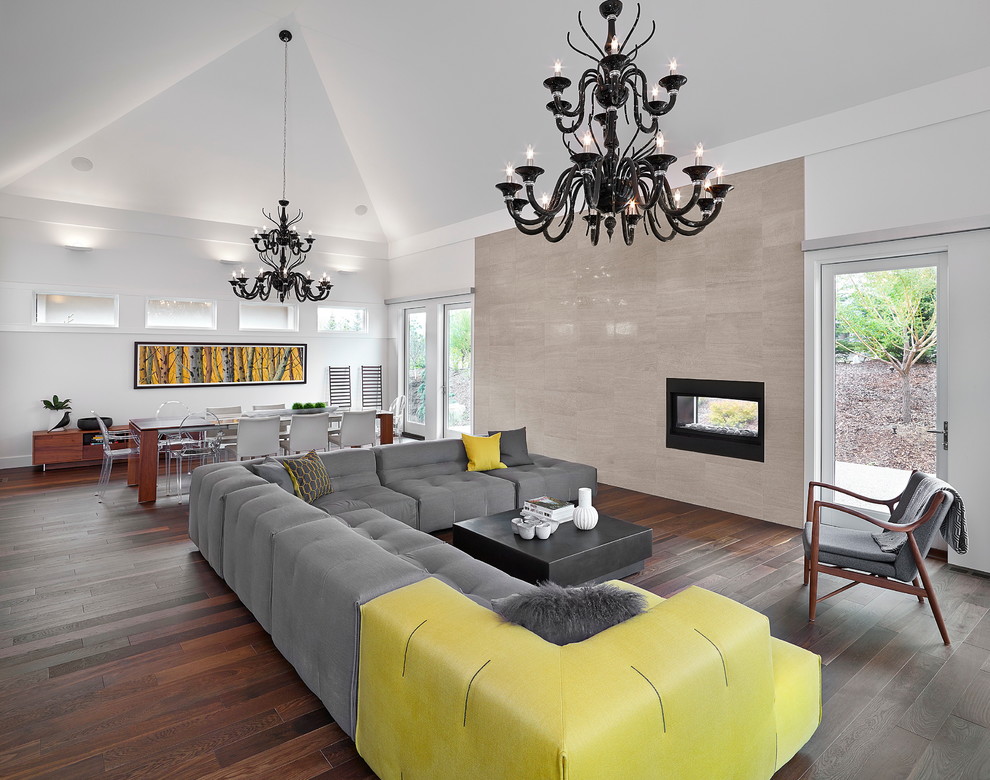 Large contemporary open concept living room in Edmonton with dark hardwood floors, a two-sided fireplace and no tv.